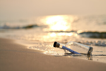Bottle with a message on sea or ocean beach. Hope concept