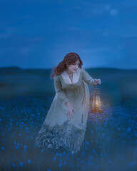 Girl with an oil lantern in the evening field of flax