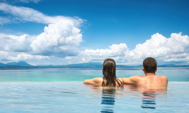 couple enjoying the view of mountain landscape from pool