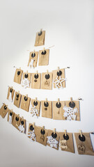 Eco-friendly zero waste large advent calendar in the form of a Christmas tree with craft bags and macrame on the wall. Craft packages for 25 days. Mockup place copy space. Concept: eco advent calendar