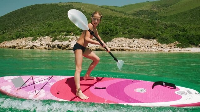 Kid rocking a stand up paddle board, SUP board in the sea