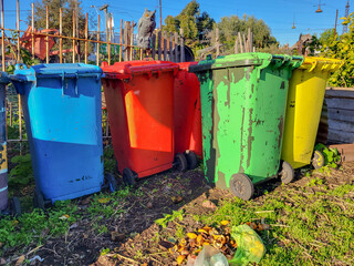 Environmental conservation in a community garden by responsibly recycling waste in compost heaps and wheelie bins.