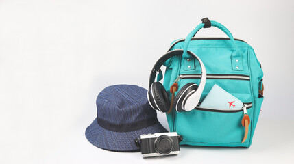 green backpack with passport cover, headphones, camera and bucket hat  on white background with...