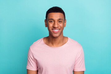 Photo of adorable sweet young guy wear pink t-shirt smiling white teeth isolated teal color background
