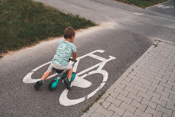 Boy on a bike. Child on balance bike riding on a bike path. Concept of healthy lifestyle, childhood