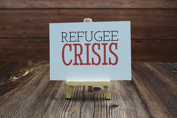 Refugee Crisis text on paper card on wooden background