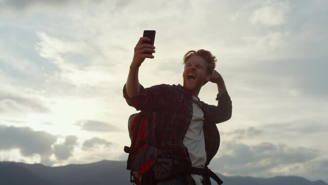 Emotional hiker posing selfie on phone camera. Travel hipster take photo outside