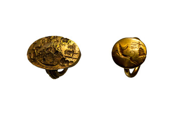 Set of 2 rings isolated on white background. The so-called ring of Minos and a golden ring depicting a griffin and a female figure with outstretched arms