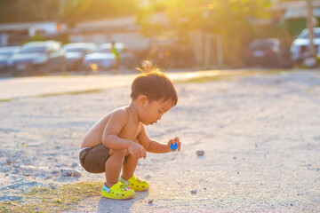 Toddler 2 year asian boy playing outdoor activity and running sunset light