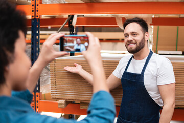 happy salesman showing stock of product in store at warehouse