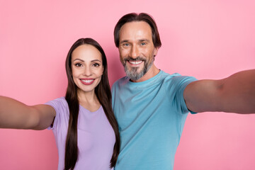Obraz premium Photo of two cheerful positive people make selfie recording video isolated on pink color background