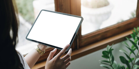 Mockup image of a woman holding digital tablet with blank white desktop screen - Powered by Adobe