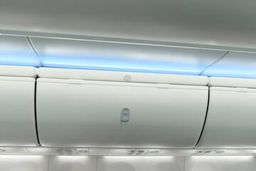 Luggage space on the top airplane shelf overhead passenger seat on a modern airplane Boeing 737-8 Max.