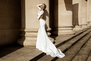 Elegant luxury fashion. Glamour, stylish elegant woman in long gown white dress is posing outdoor....
