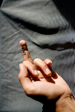 Close up hand showing middle finger up with word liebe written on it
