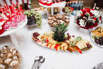 Delicious and tasty dessert table with cupcakes shots at reception closeup
