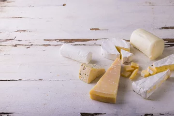 Foto op Aluminium High angle view of various cheese on white wooden table, copy space © wavebreak3