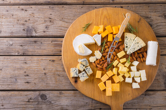 Directly above shot of various cheese with knife and almonds on table, copy space