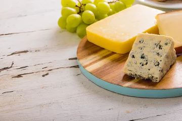  Close-up of various cheese with grapes on table, copy space © wavebreak3