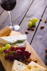 Tuinposter High angle view of cheese by grapes with almonds and red wine on table, copy space © wavebreak3