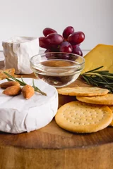 Foto op Plexiglas Close-up of cheese by grapes with almonds and crackers on wooden board, copy space © WavebreakMediaMicro