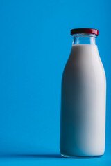 Close-up of milk bottle against blue background with copy space