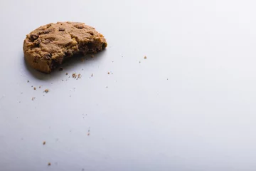 Fotobehang High angle view of half eaten cookie on white background with copy space © WavebreakMediaMicro
