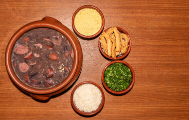 Delicious feijoada bowl with side dishes. Brazilian typical cuisine made with black beans and pork.
