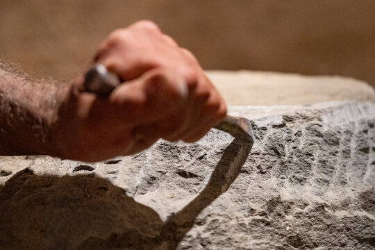 Mano di scultore scolpisce pietra serena