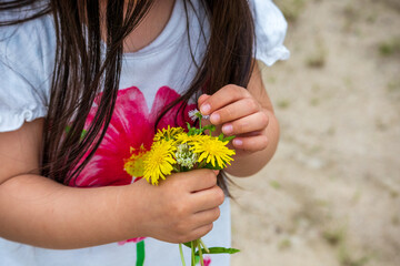 自分で摘んだ花を抱える女の子