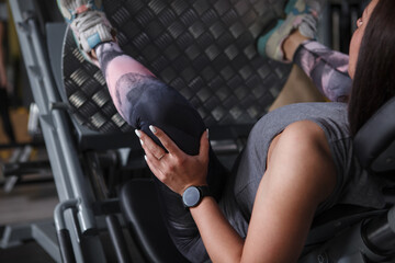 Cropped rear view shot of a female athlete working out on leg press gym machine