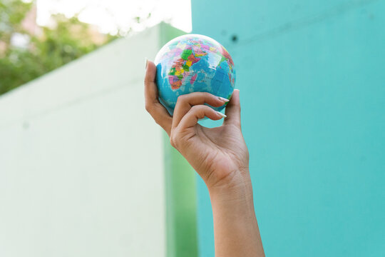 Anonymous woman looking at small globe