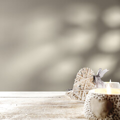 White wooden worn desk with candles and wall with shadows 