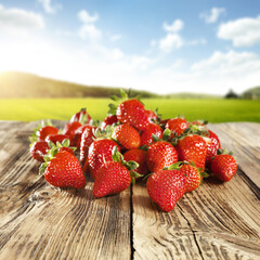 Fresh red fruits on desk and landscape 