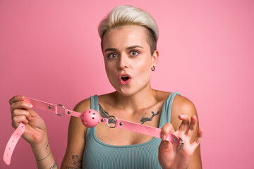Stunning girl holding mouth bdsm gag toy for playing pervert fetish game and looking at the camera