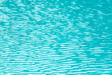 Ripple Water in swimming pool with blue tile floor background