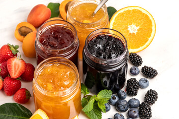 Jam in jar and berries strawberry apricot  orange, blueberries blackberries