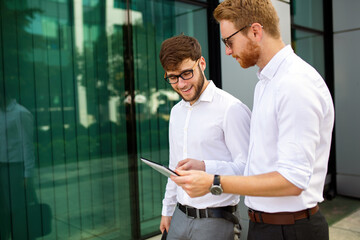 Two successful business men walking outdoors. Business, friendship, communication concept