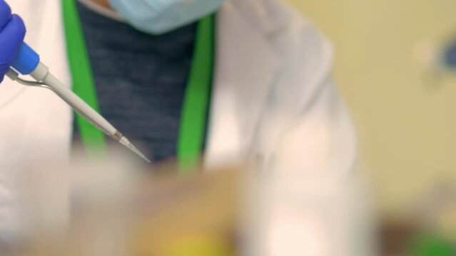 4k real time - hospital staff carrying out medical research in the laboratory with pipettes, test tubes, samples, etc...