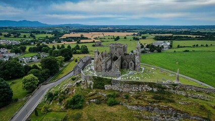 Rock of Cashel against green fields and a cloudy sky, County Tipperary, Ireland