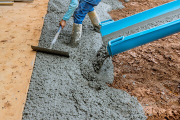 Process of pouring cement on a new driveway for residential property in construction site