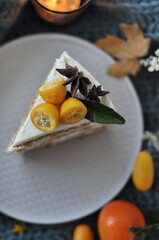 white cake on a plate with kumquat on top