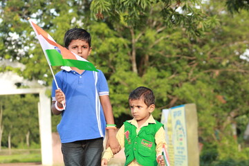 little indian boys proudly holding Tricolour Indian National flag.