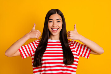 Photo of sweet cute young lady wear red clothes showing two thumbs up isolated yellow color background