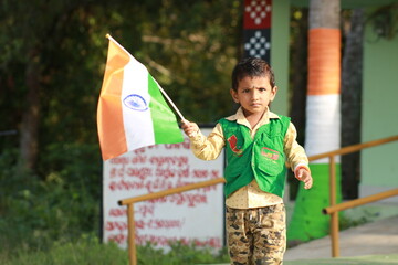 little indian boy proudly holding Indian National flag. The national flag of India, colloquially...