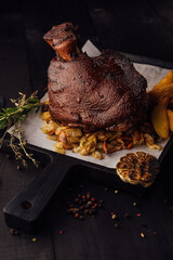 Roasted pork knuckle eisbein with on wooden cutting board