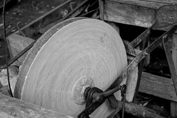 Closeup grayscale shot of antique grindstone for sharpening knives