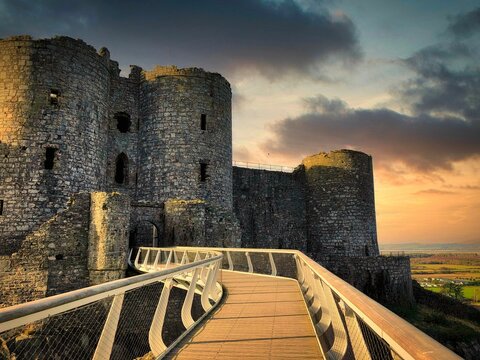 Scenic view of a bridge leading to the Harlech castle at sunset in Wales