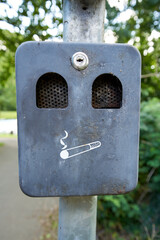 A metal ashtray for cigarette disposal in the style of an old post box