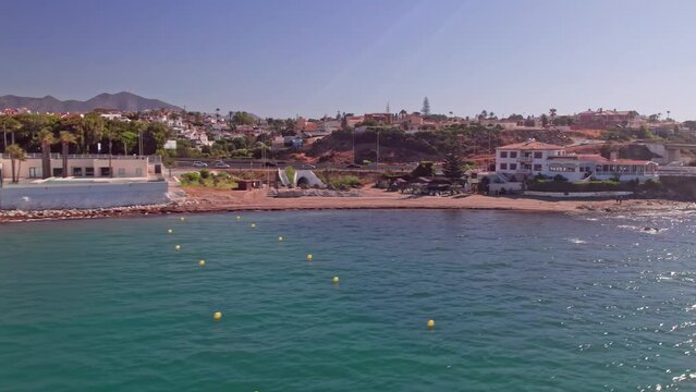 Aerial shot of the coastline in Mijas Costa with resorts and road traffic